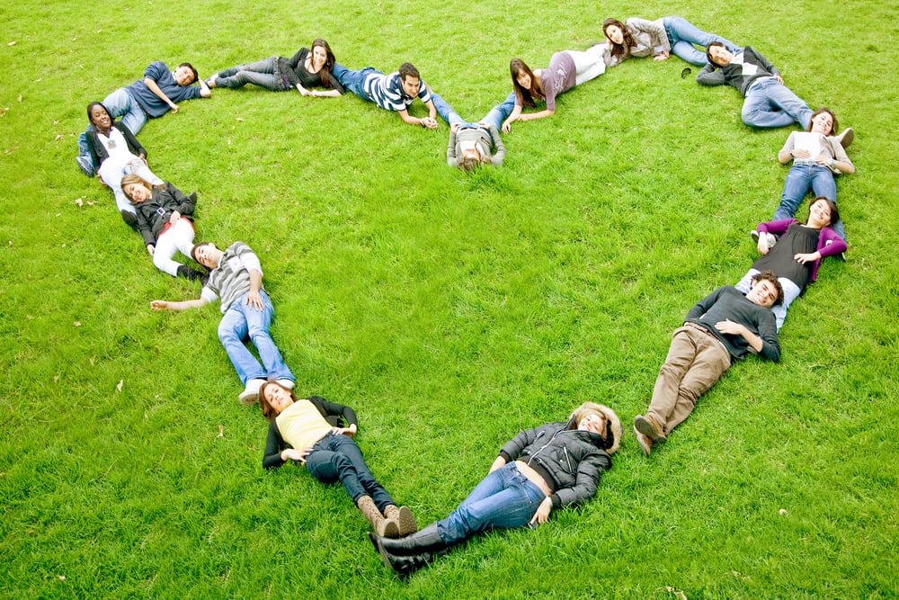 World Vision happy friends making a heart shape - smiling outdoors in a park